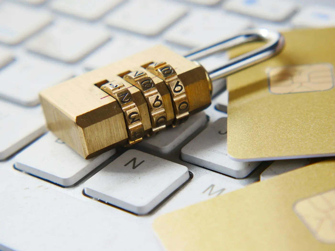 Cadenas à code posé sur un clavier à côté de cartes bancaires, symbole de sécurité